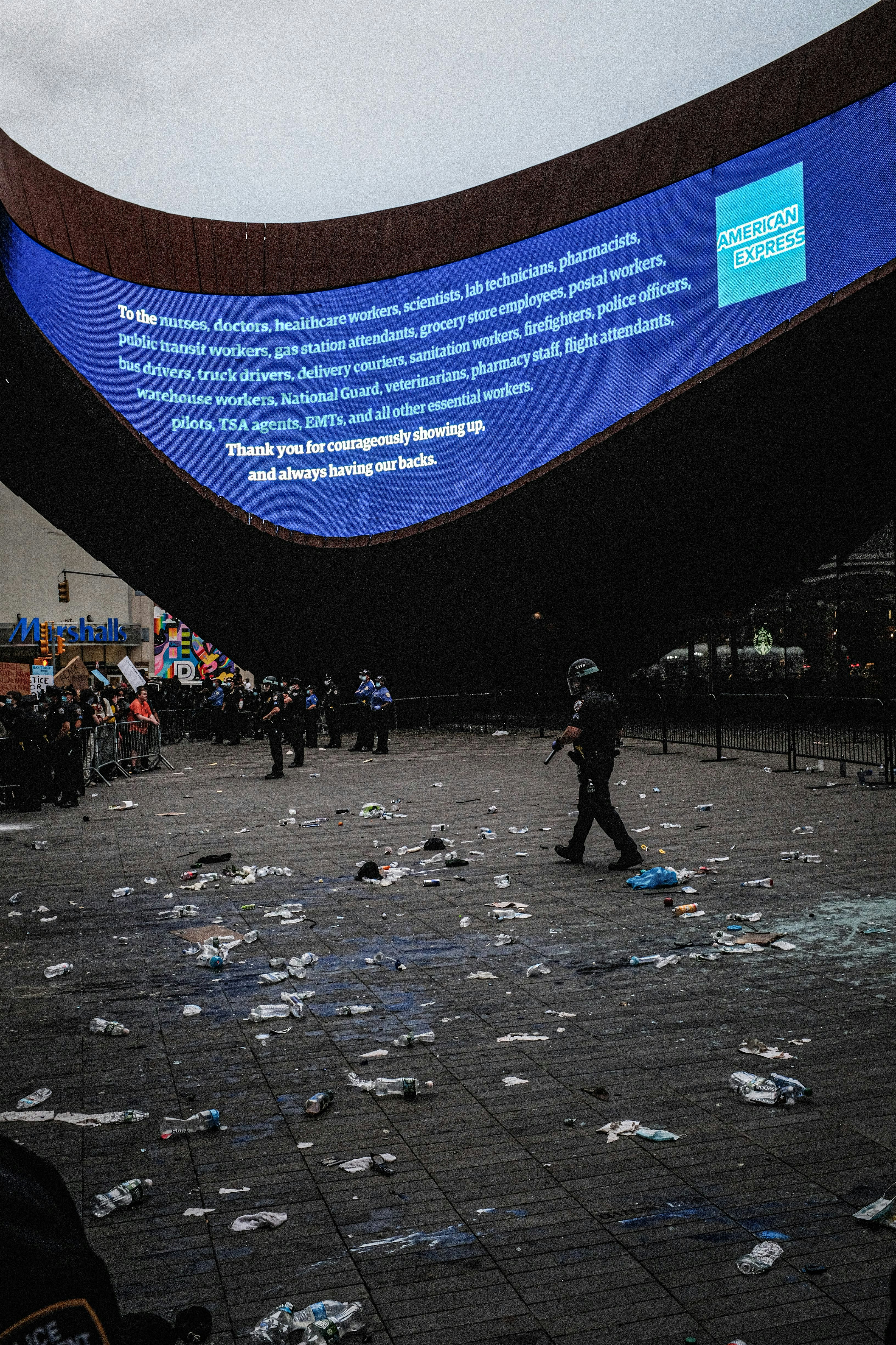 a group of people standing around a pile of trash