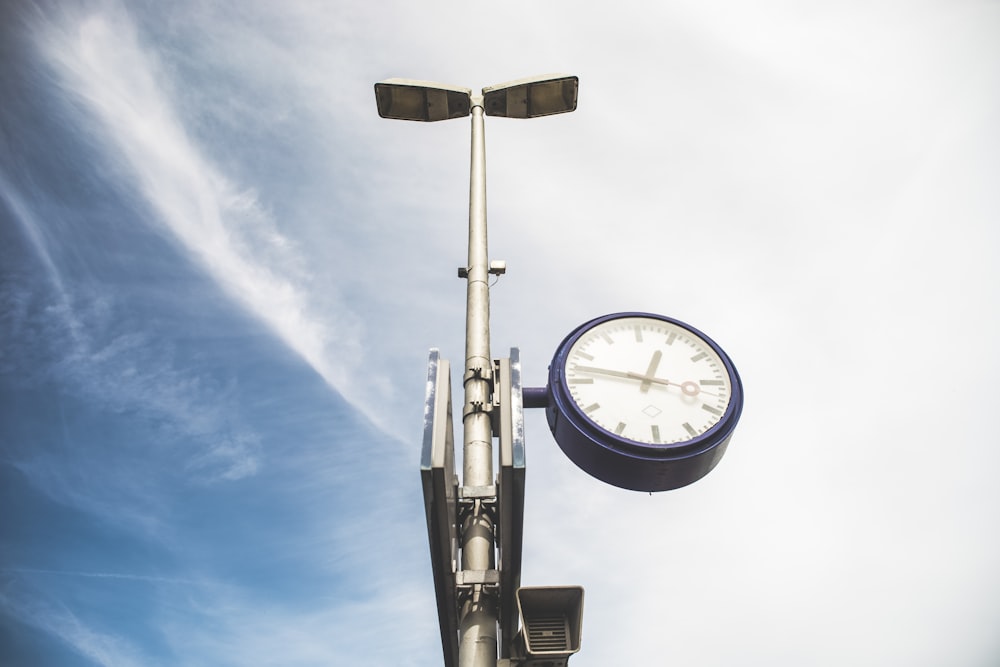 a clock that is on the side of a pole