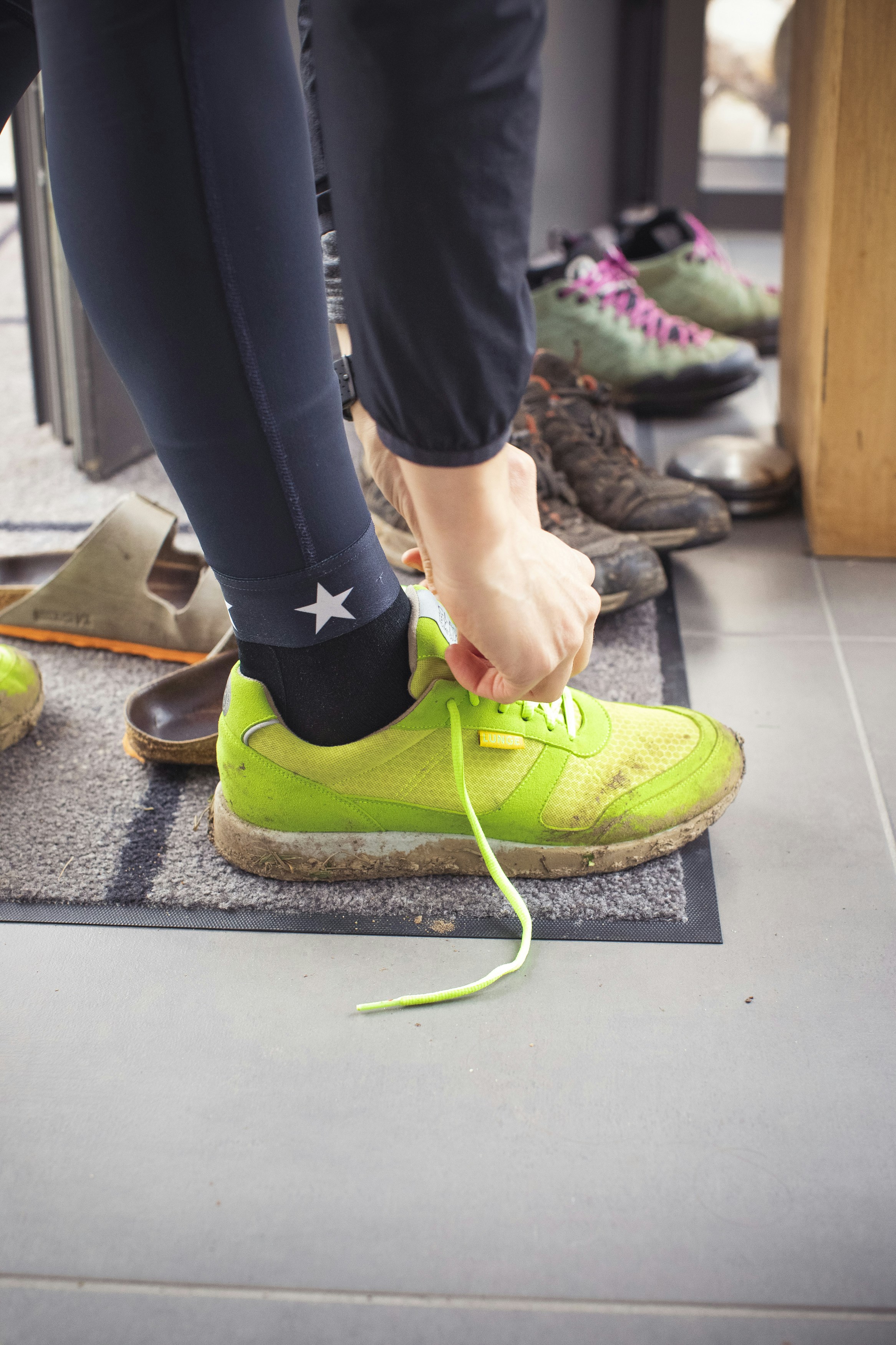 una persona che lega un laccio di scarpe a un paio di scarpe