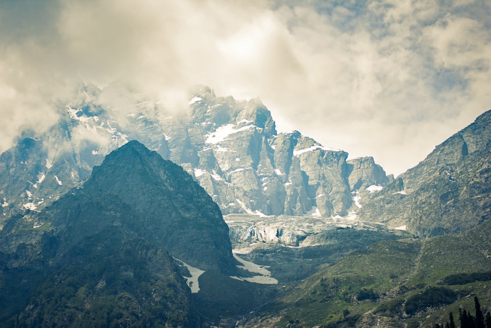 a mountain range covered in snow and clouds