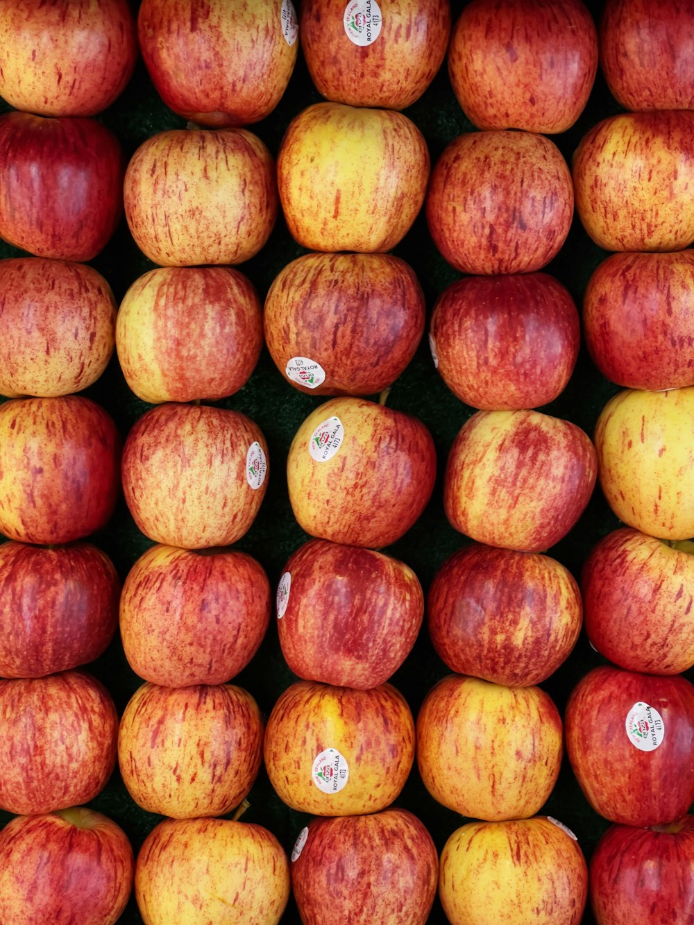 a pile of red and yellow apples sitting next to each other