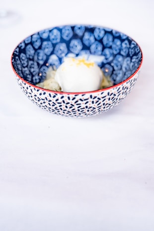 Close-up of a colorful artisanal ice cream scoop in a minimalist white bowl.