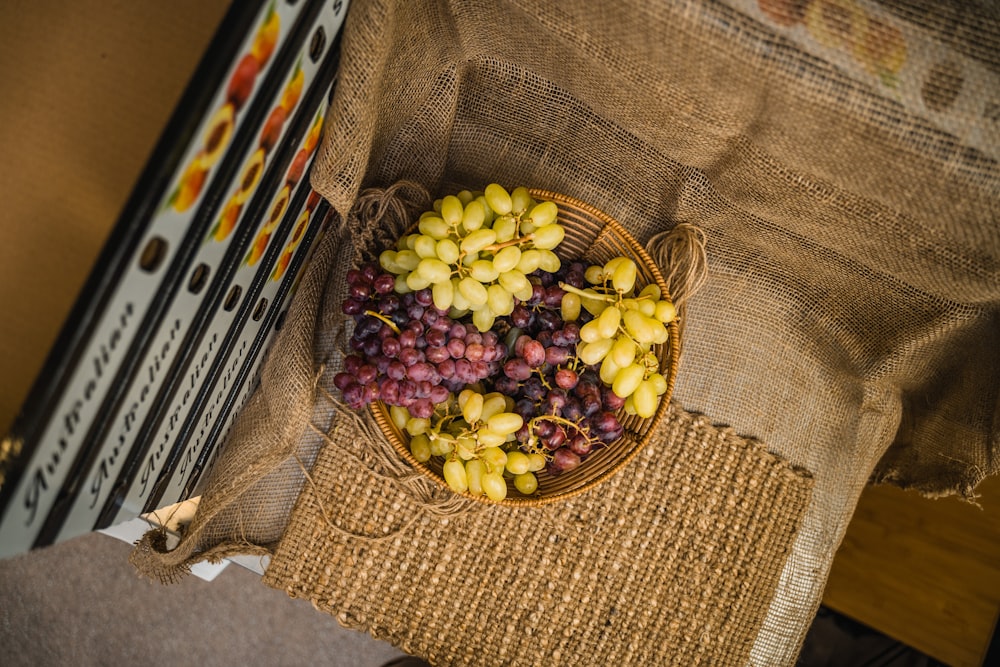 a basket filled with grapes sitting on top of a table