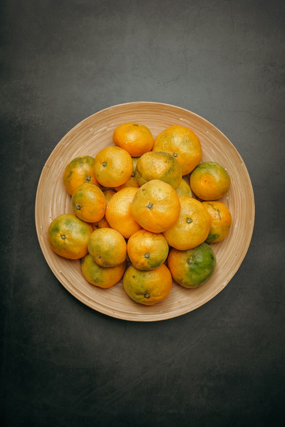 a bowl full of oranges and limes on a table