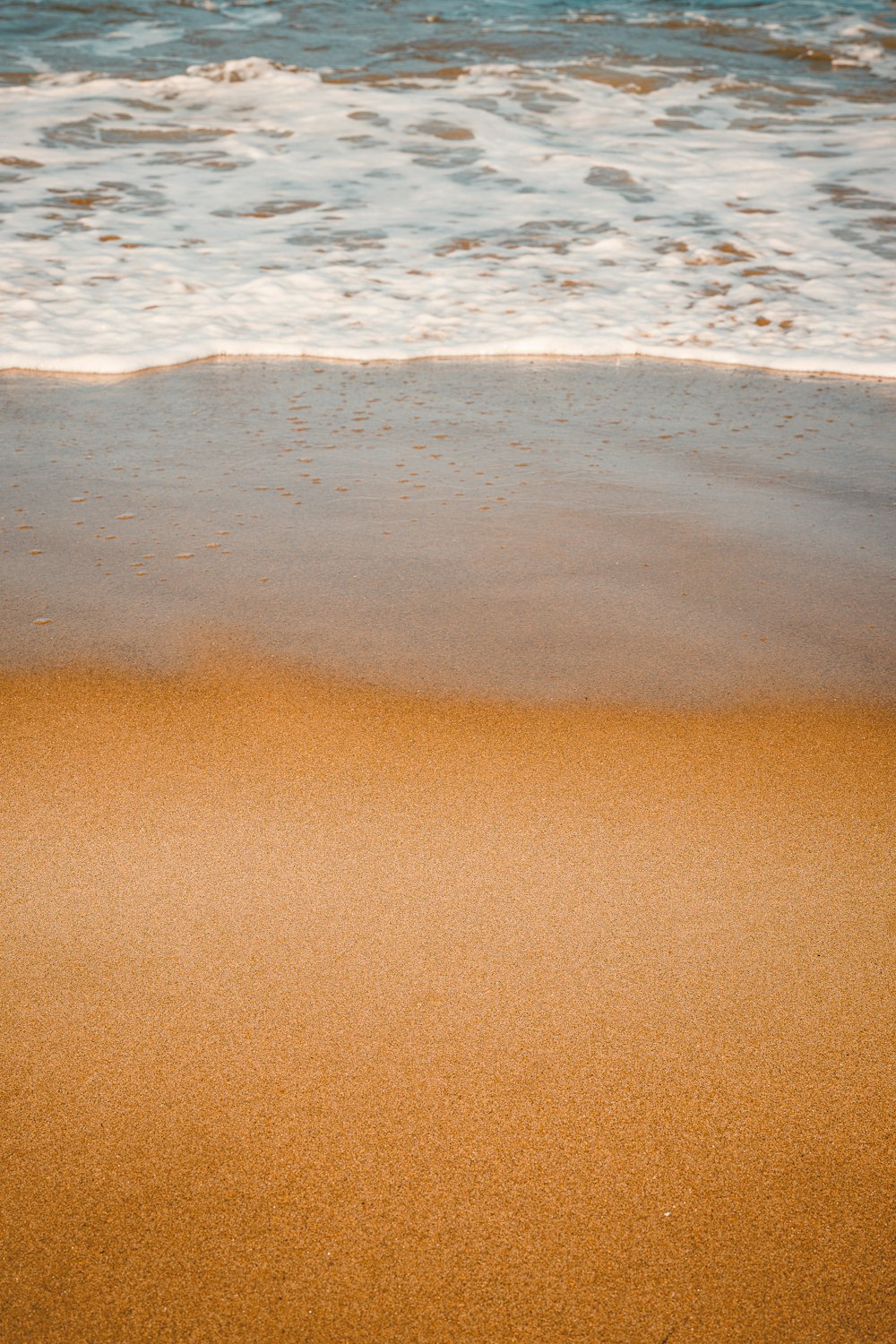 une plage de sable au bord de l’océan avec des vagues qui arrivent