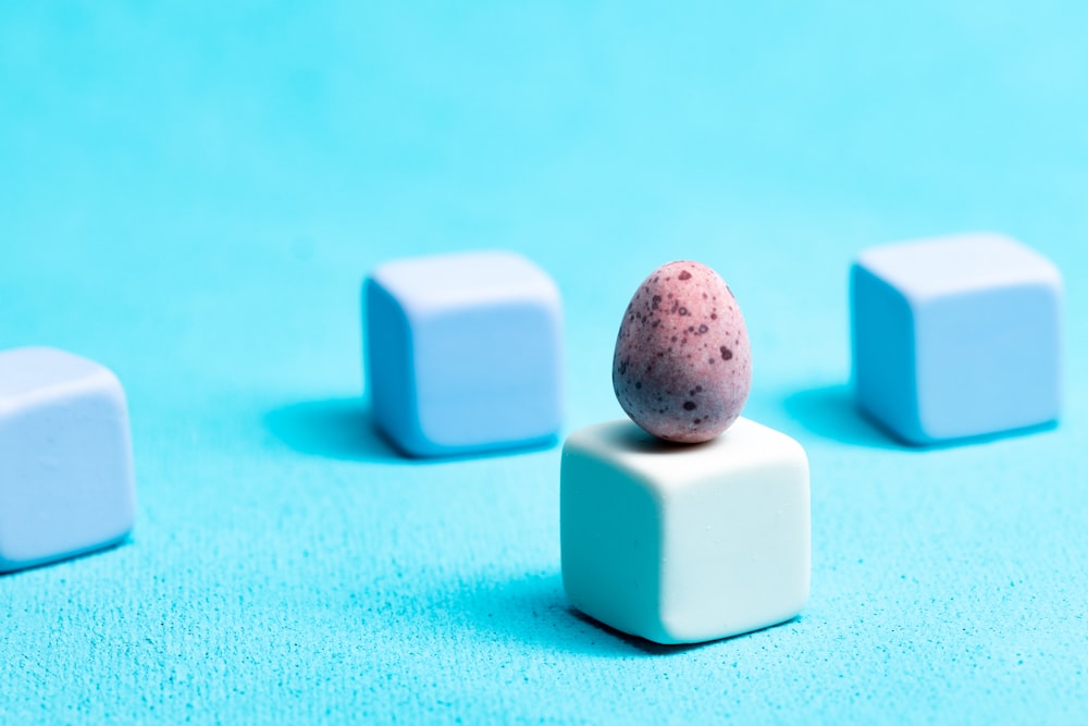 a small egg sitting on top of a white block