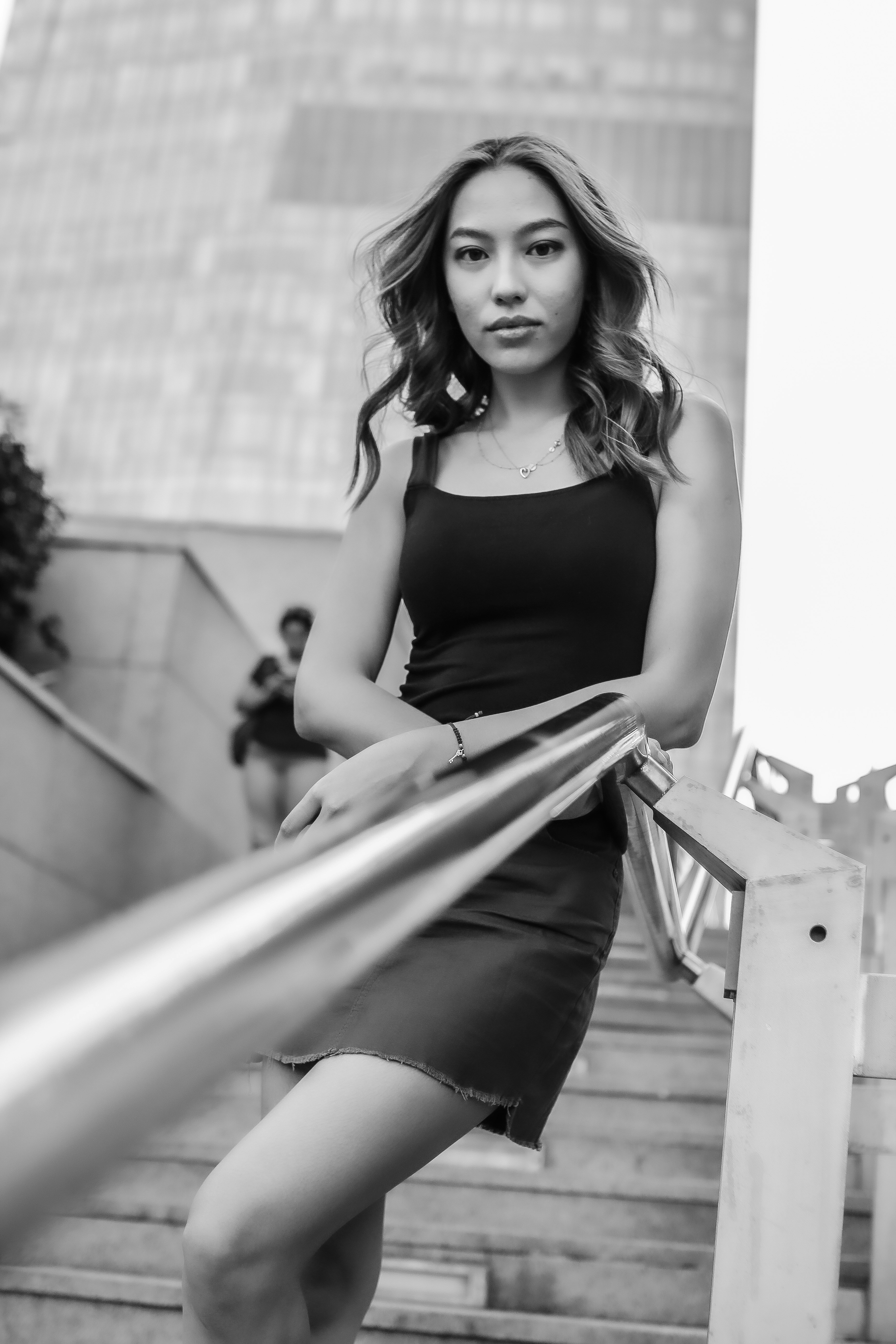 a woman in a black dress standing on some stairs