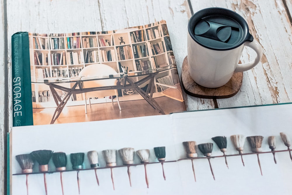 una tazza di caffè seduta sopra un tavolo accanto a un libro