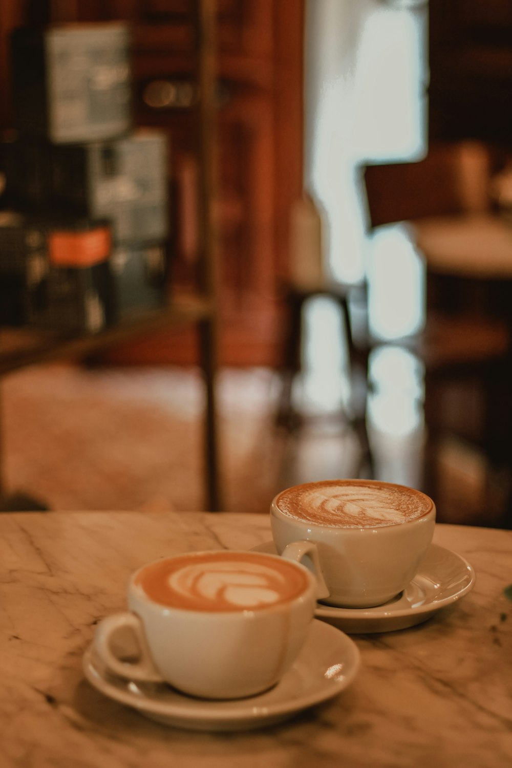 two cups of coffee sitting on top of a table