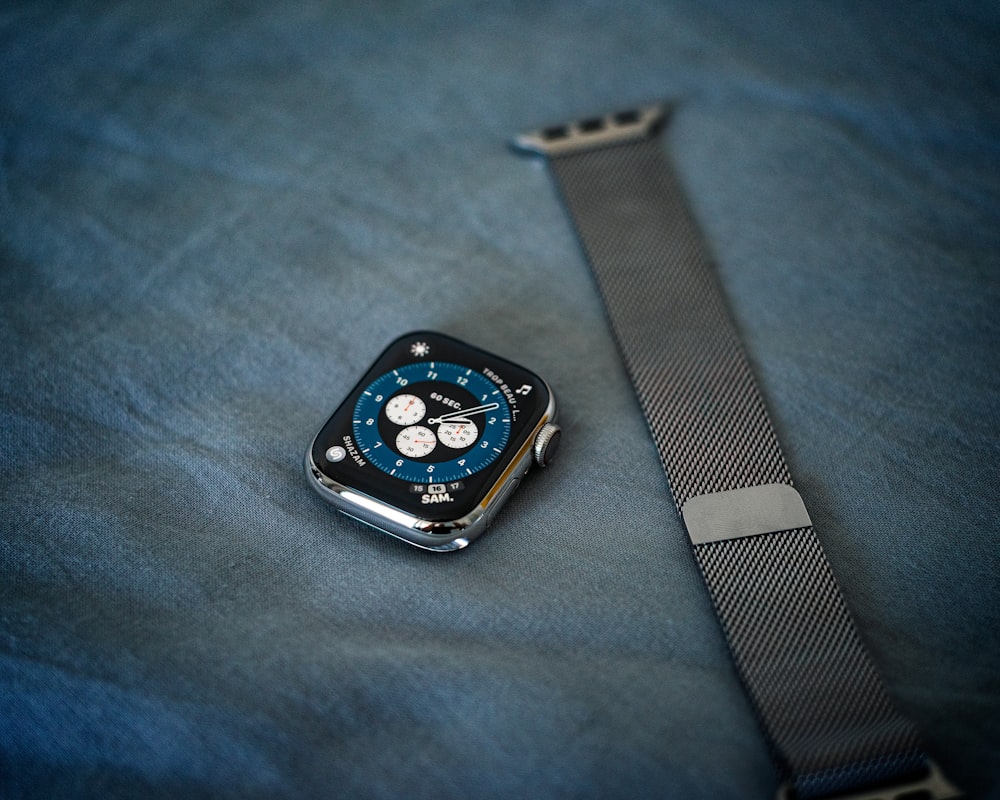 a watch sitting on top of a blue cloth