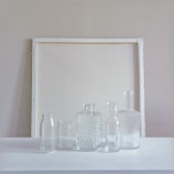 Minimalist still life featuring Nouveau Water bottles arranged on a smooth white surface.