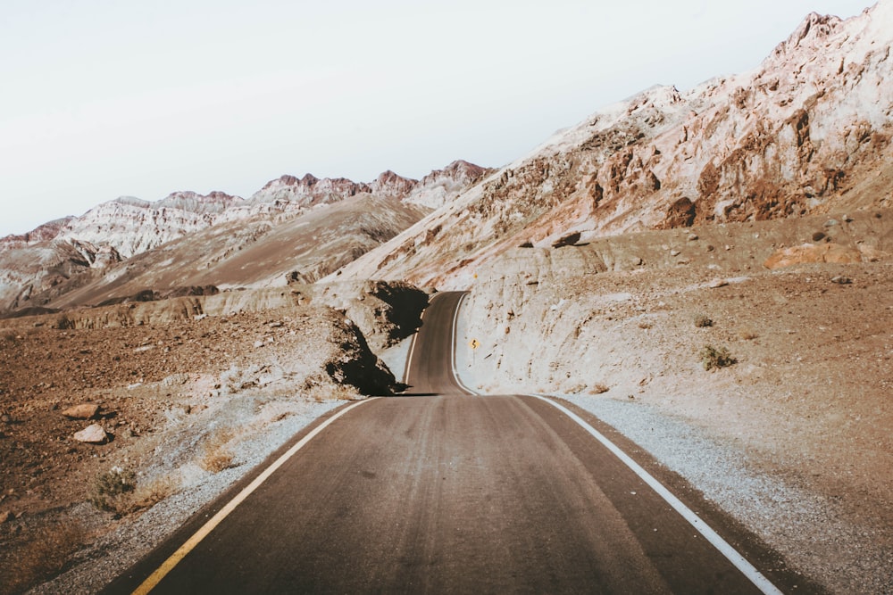 a road in the middle of a desert with mountains in the background