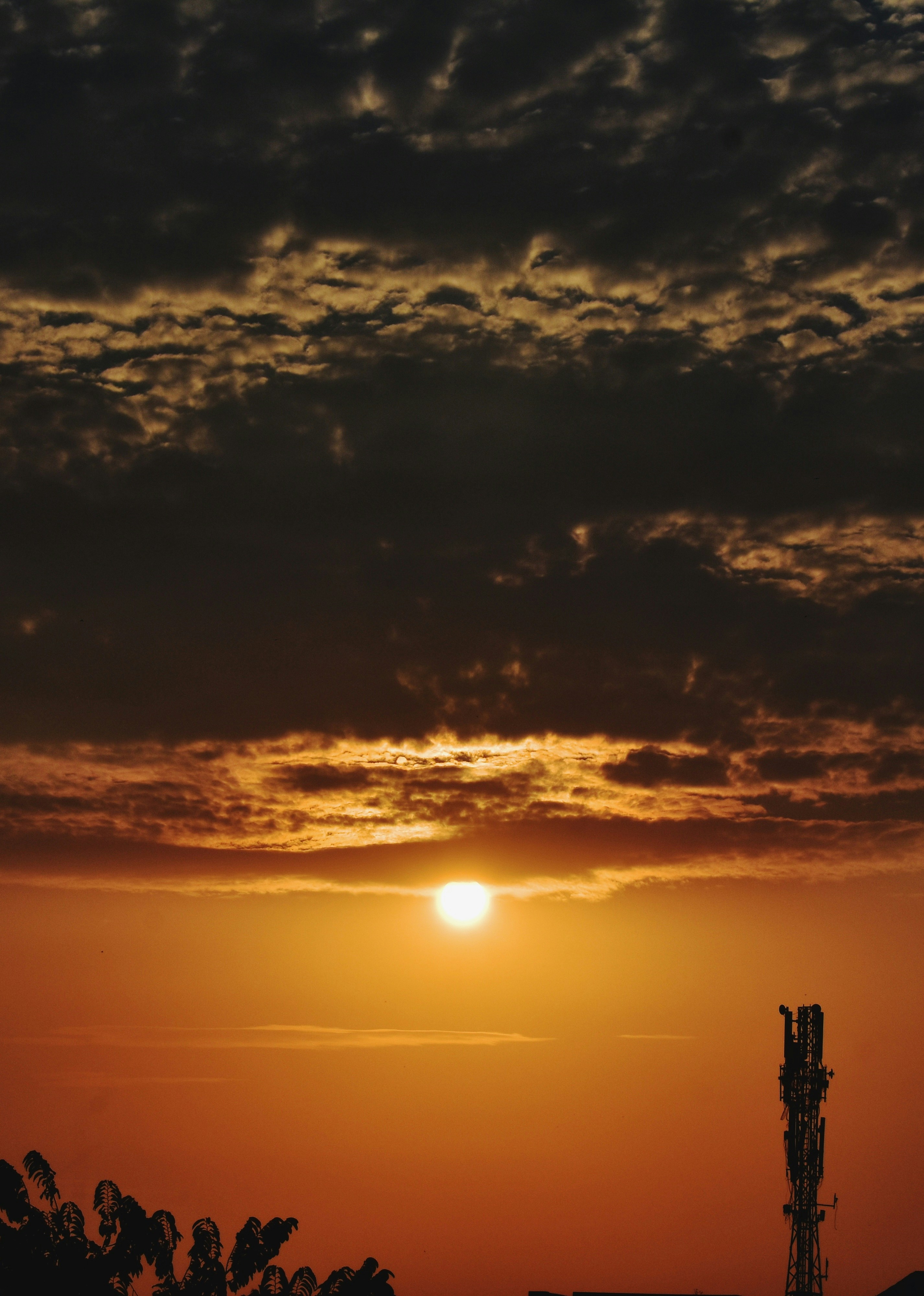 Il sole sta tramontando dietro una torre nel cielo