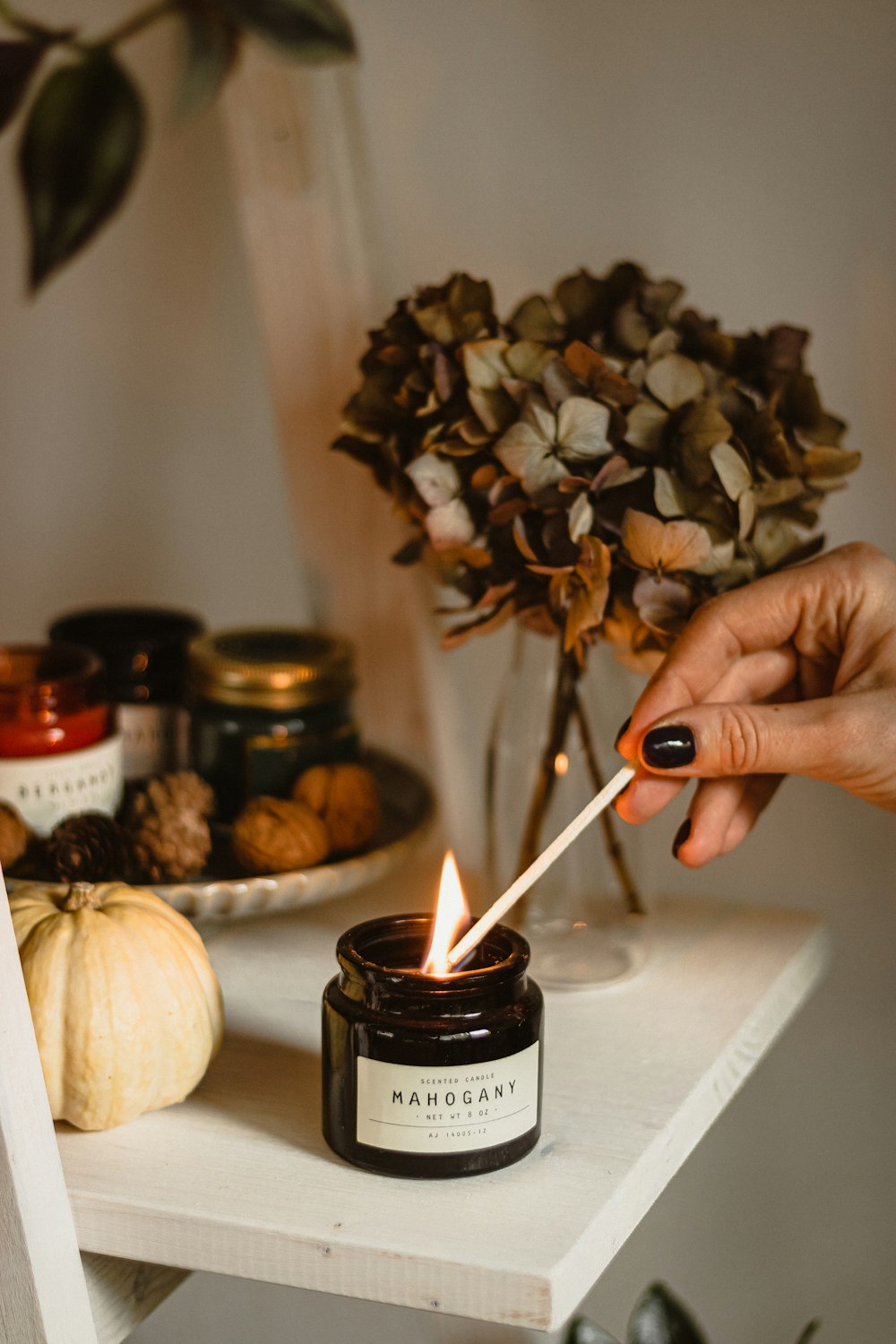 a person lighting a candle on a shelf