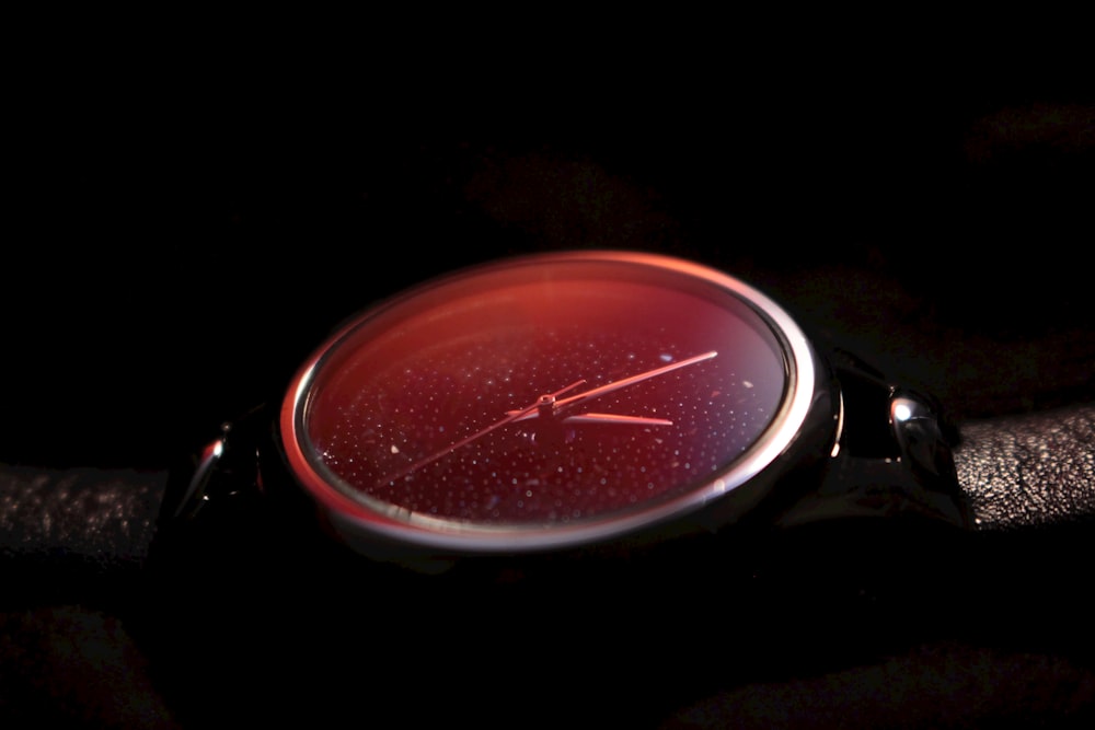 a close up of a watch on a black surface