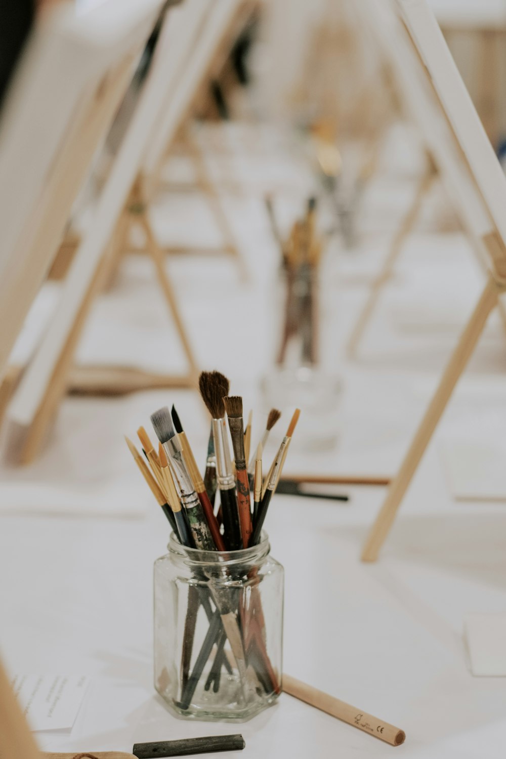 a jar filled with paint brushes sitting on top of a table