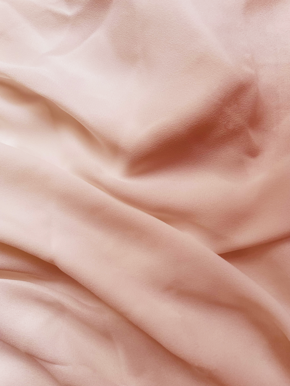 a close up of a bed with a pink comforter