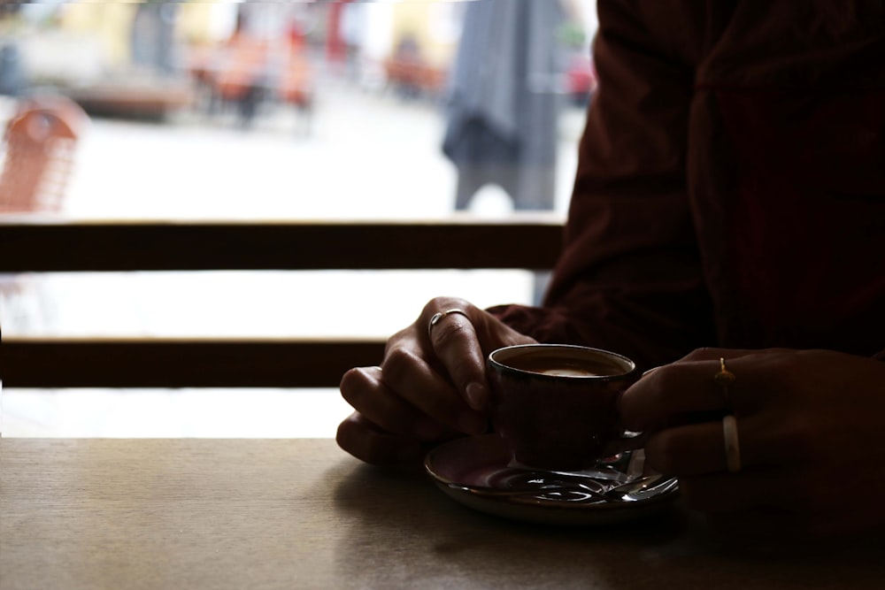 커피 한 잔과 함께 테이블에 앉아있는 사람