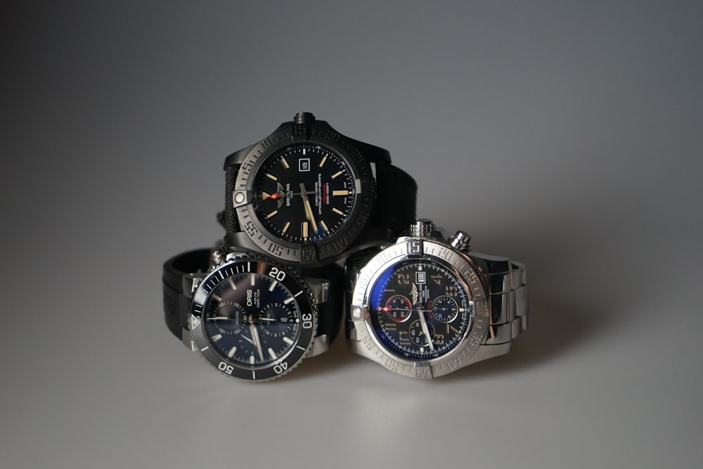 three watches sitting next to each other on a table