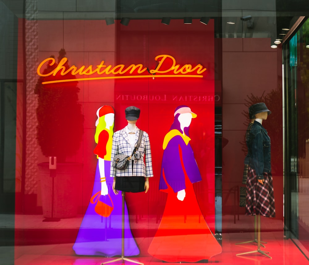 two mannequins in front of a christian dior store