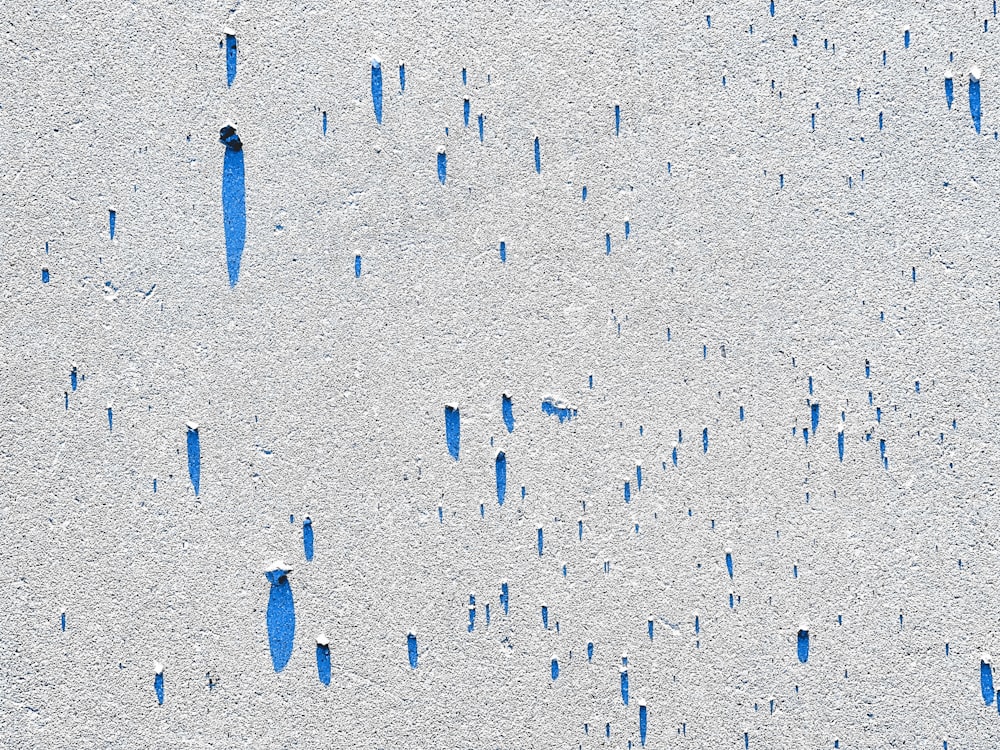 a group of blue sticks sticking out of the sand