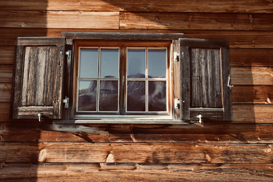 a window with wooden shutters on the side of a building