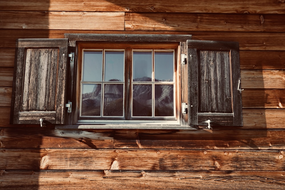 a window with wooden shutters on the side of a building