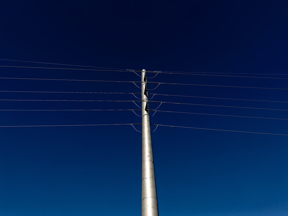 a tall metal pole sitting next to power lines
