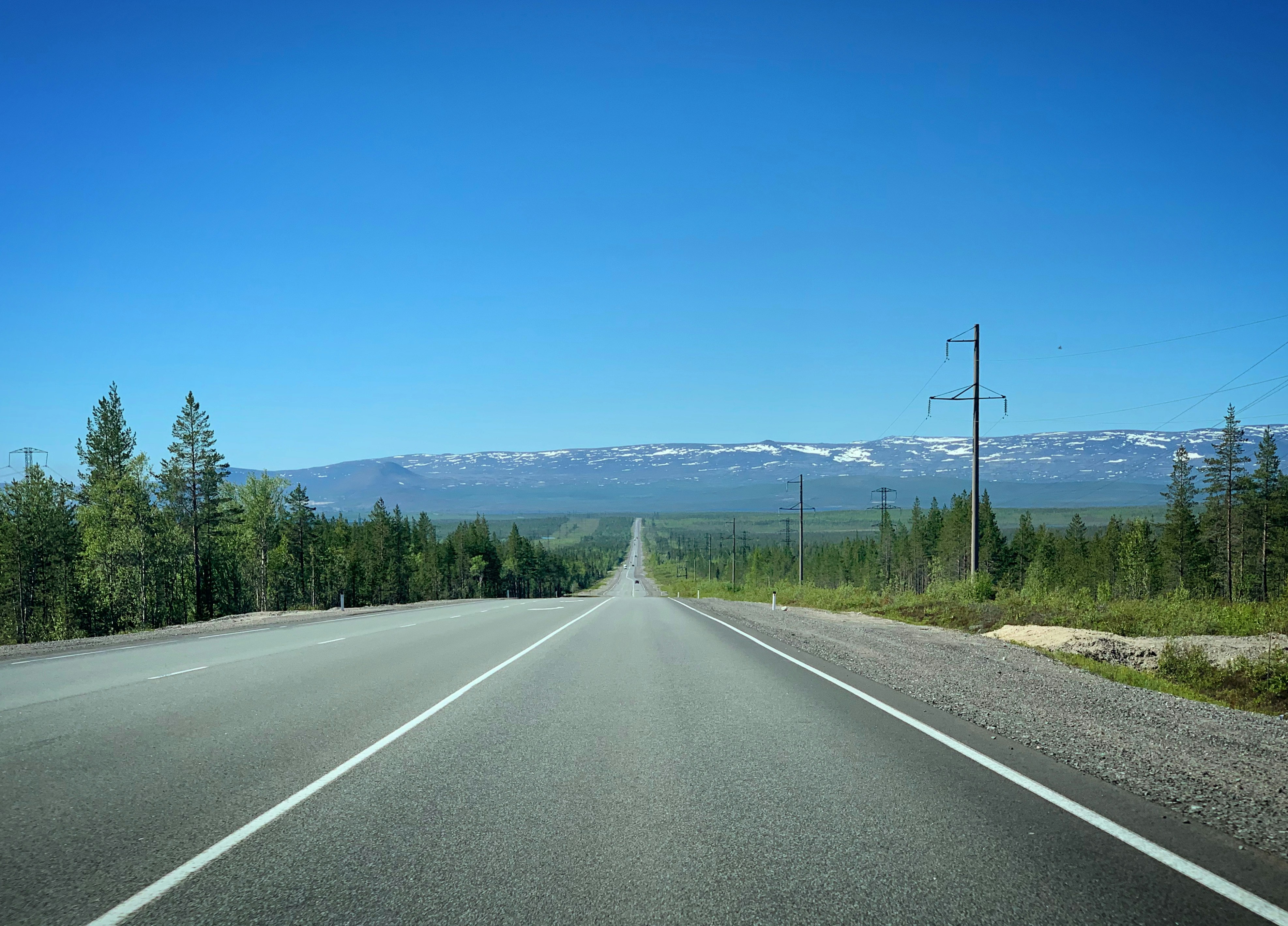 an empty road with a mountain in the background