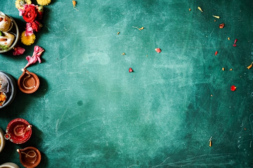 Brightly colored flower petals scattered around a traditional Indian letter.