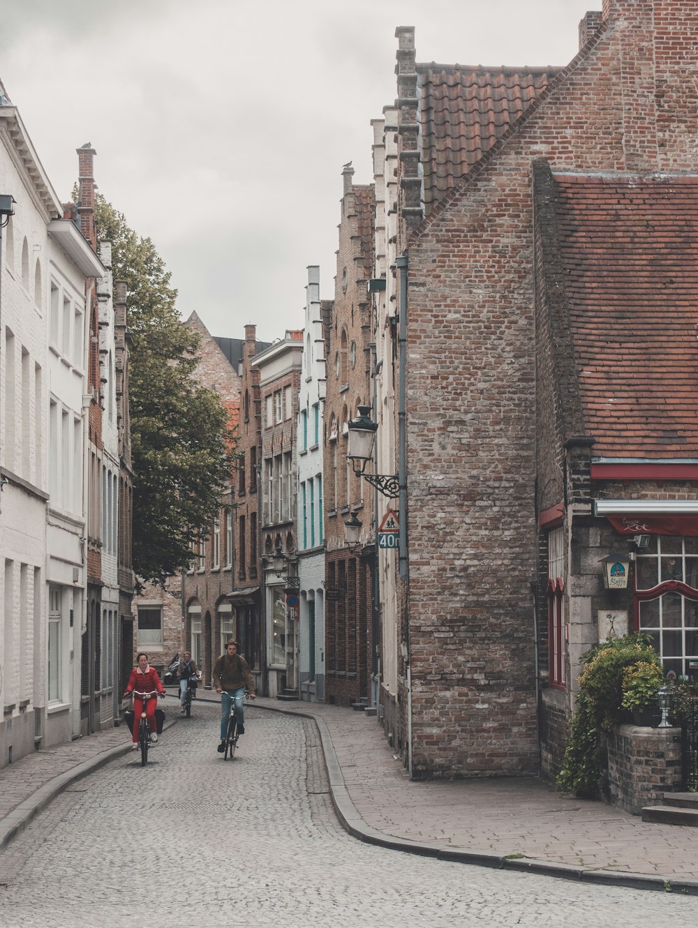 a group of people walking down a cobblestone street