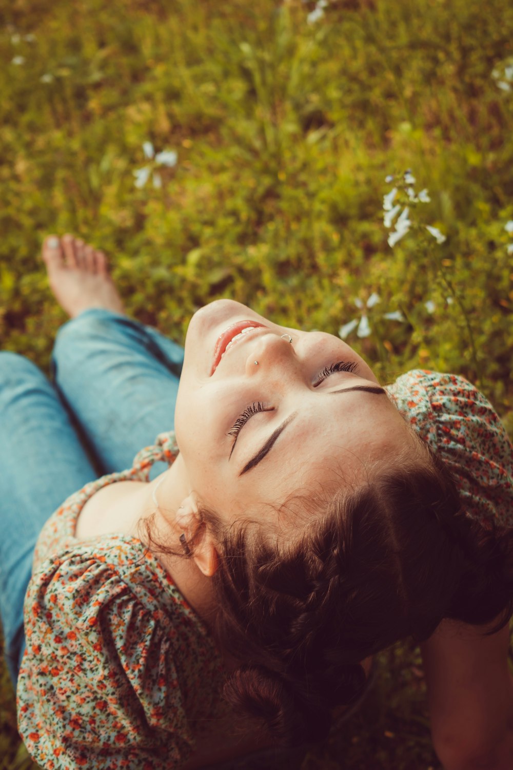 a woman laying in the grass with her eyes closed