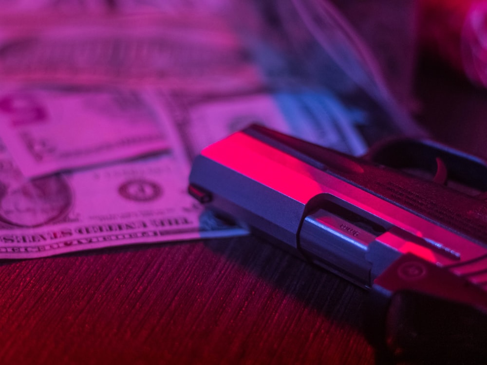 a gun sitting on top of a pile of money