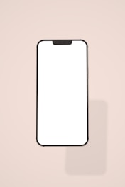 a white phone with a black frame on a pink background