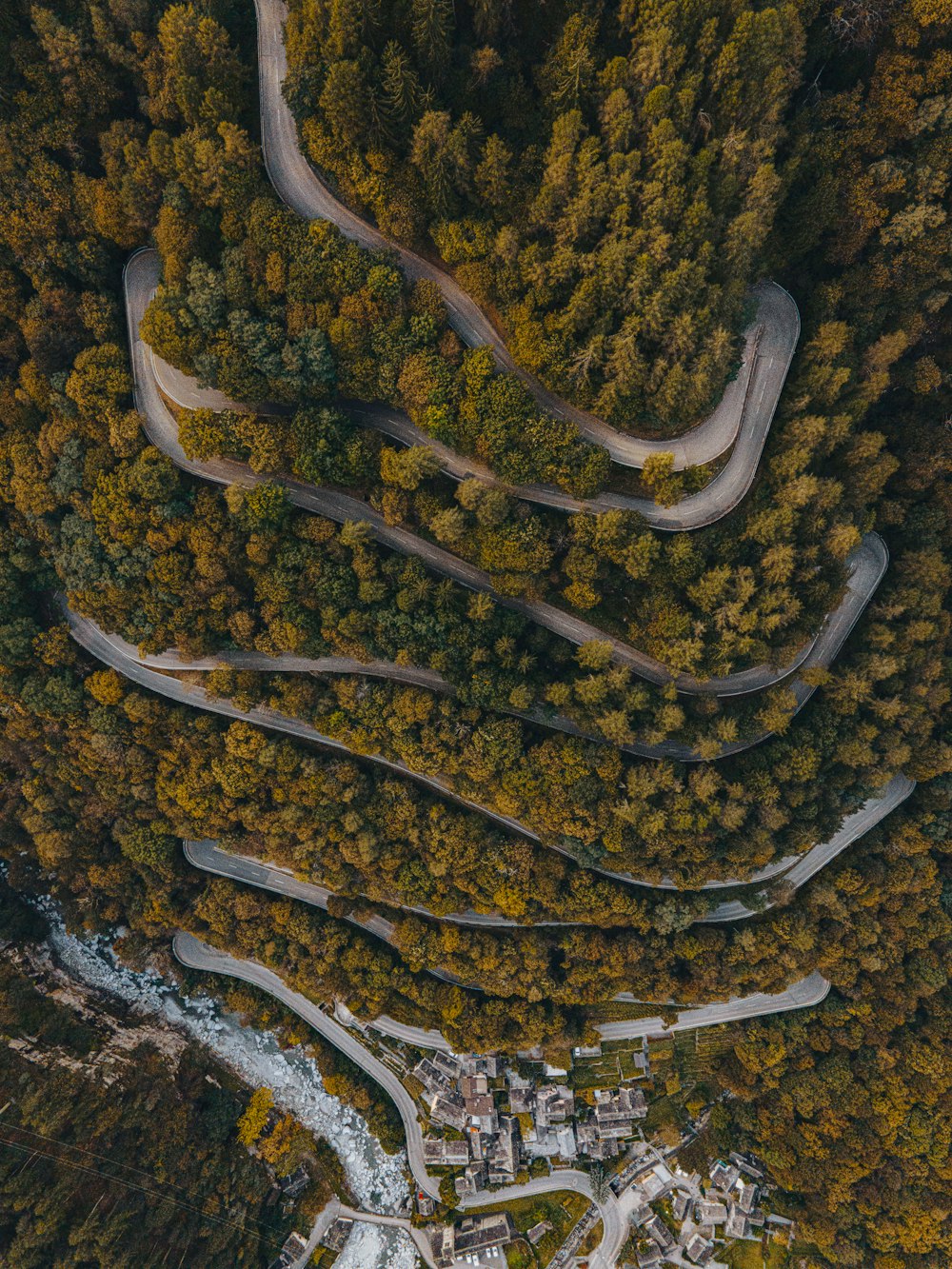 an aerial view of a winding road surrounded by trees