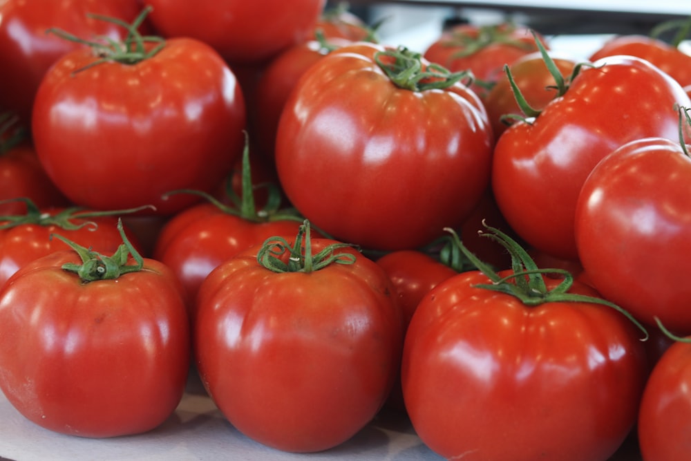 a pile of tomatoes sitting on top of a table