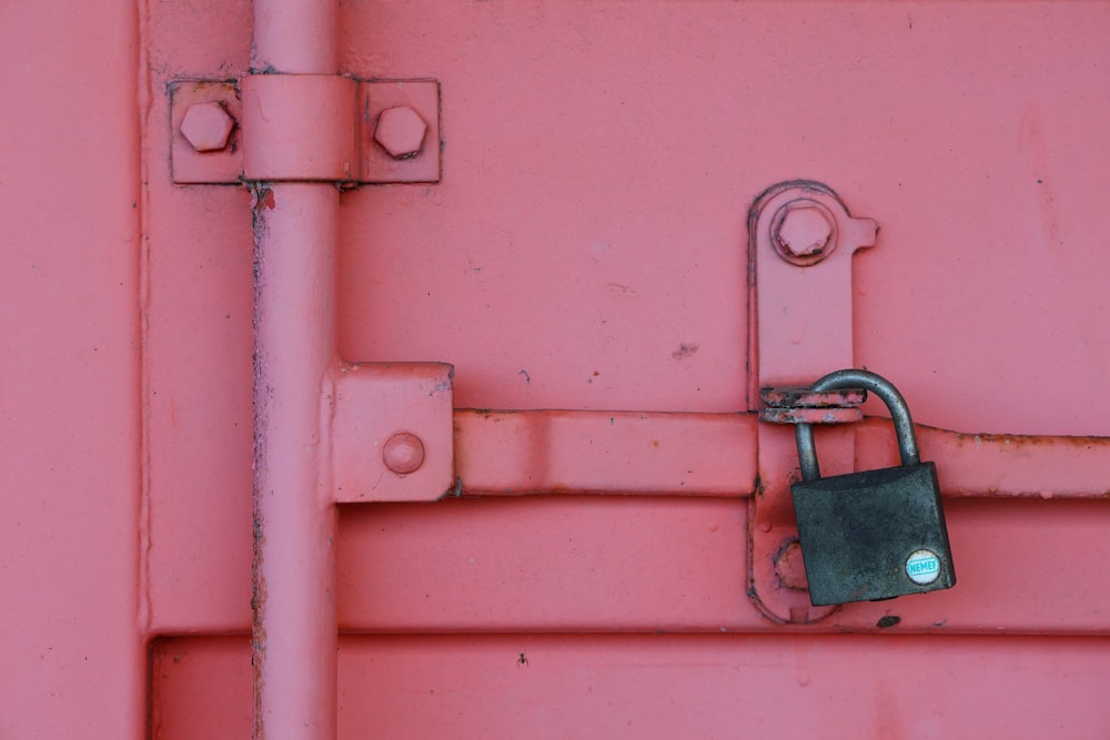 a close up of a padlock on a pink wall
