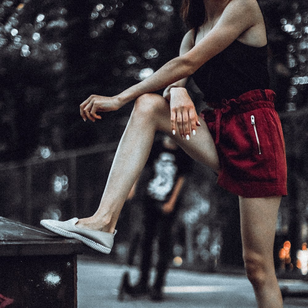 a woman sitting on top of a wooden bench