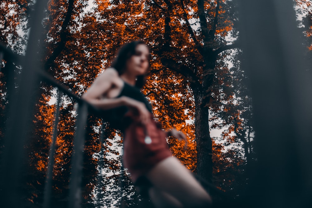 a woman standing in front of a tree in a forest