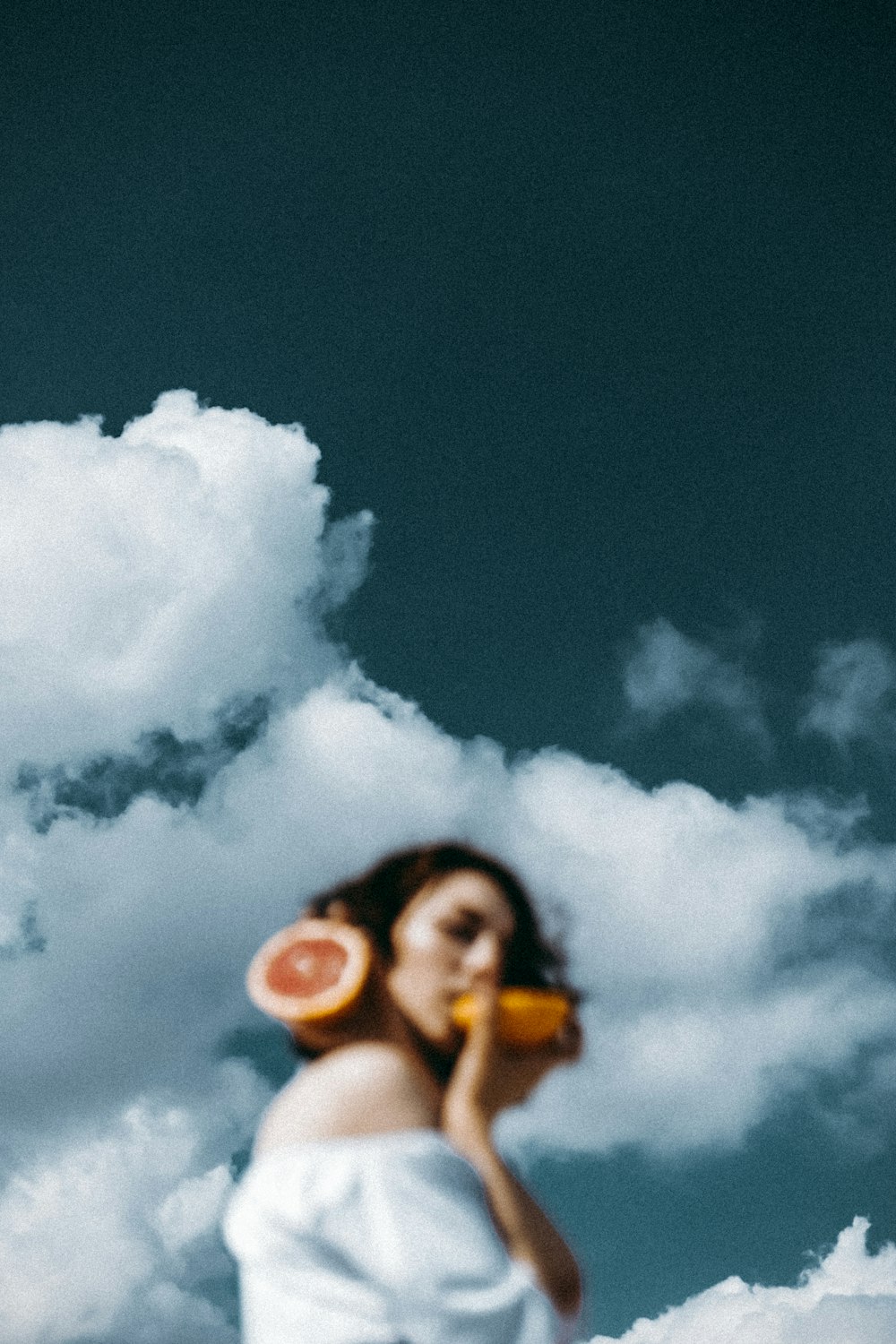 a woman in a white dress holding a watermelon slice