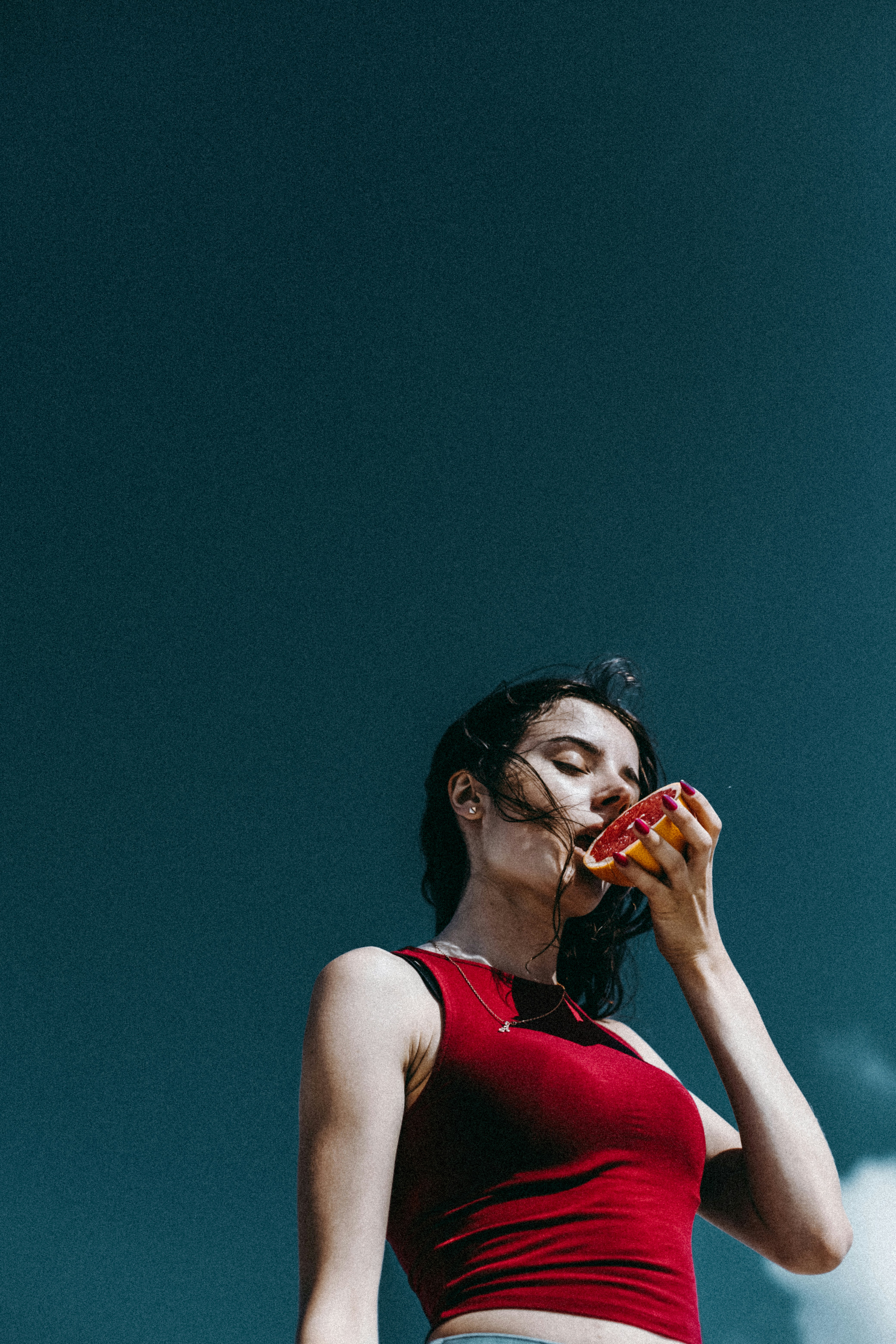 a woman in a red top eating a donut