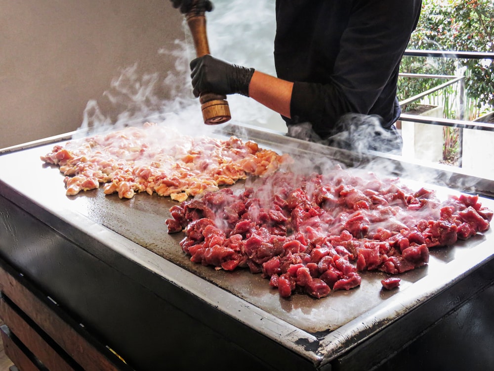 a person cooking food on top of a grill