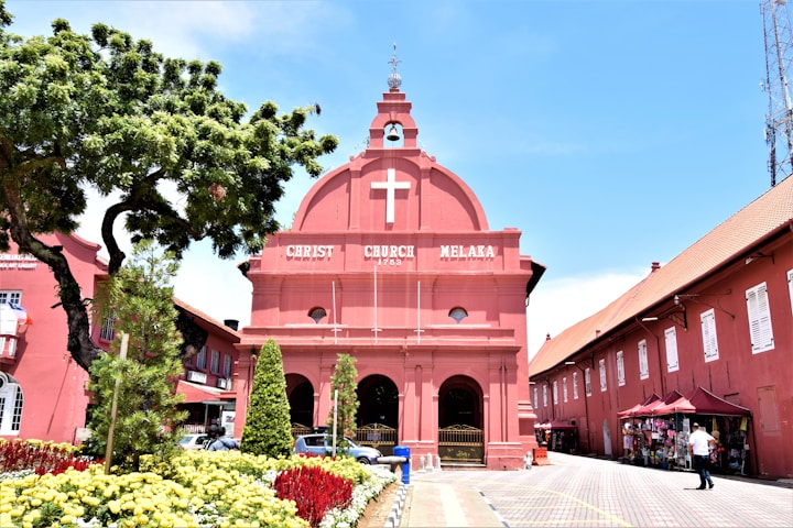 a pink building with a cross on the top of it