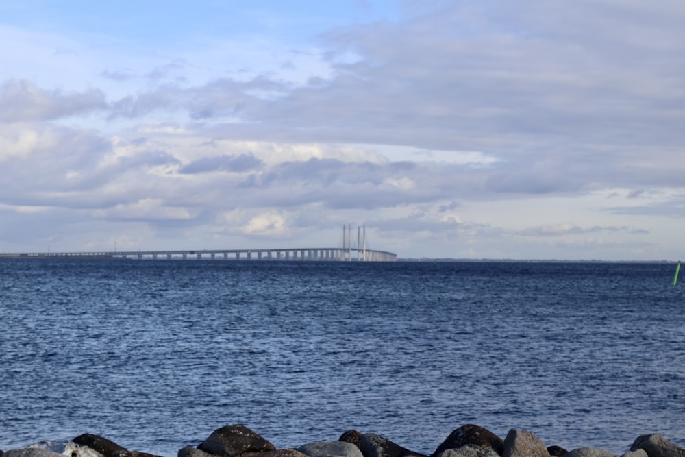 a large body of water with a bridge in the background