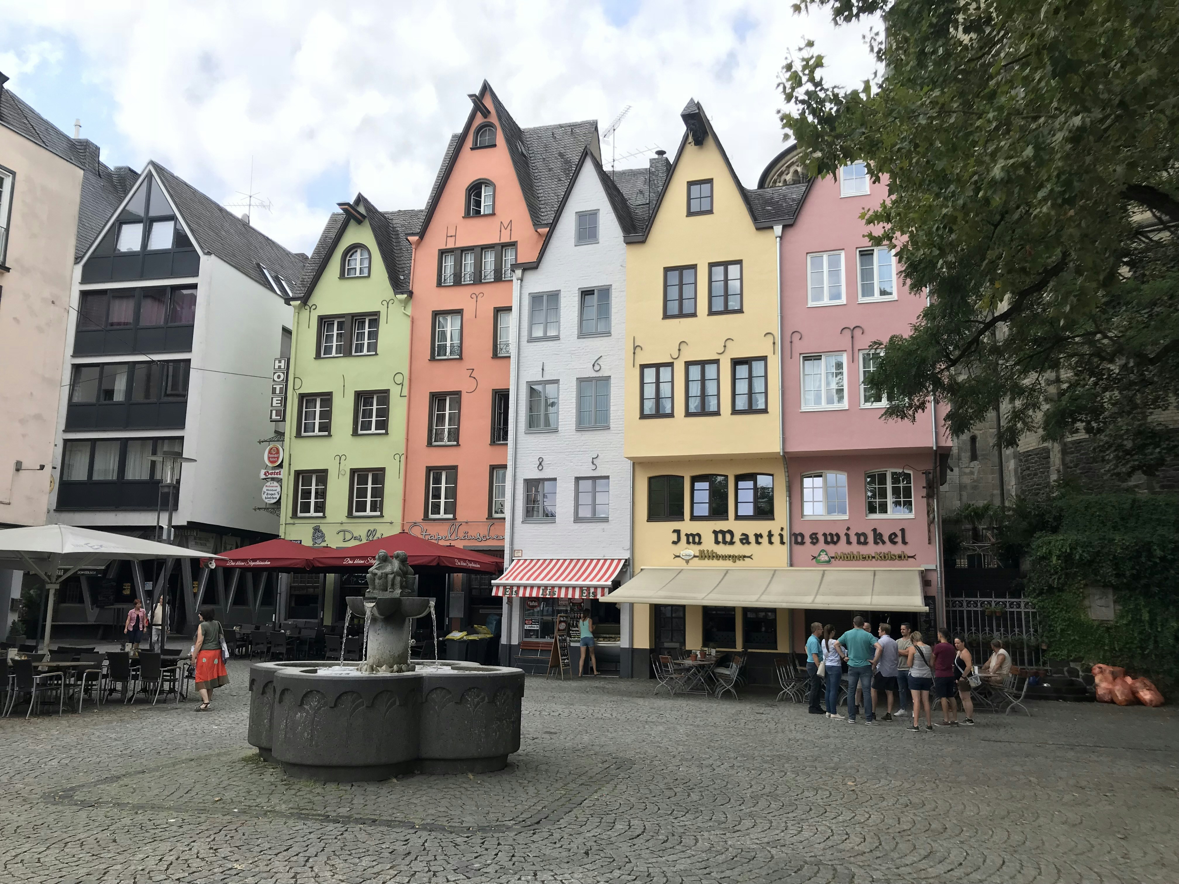 a group of people sitting around a fountain in a courtyard
