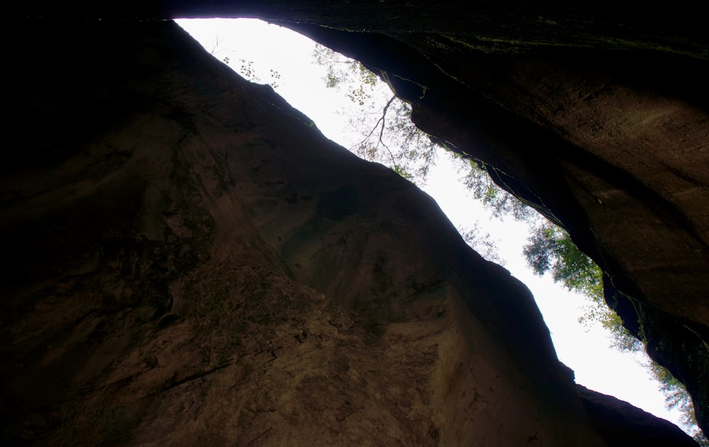 a view of the sky from inside a cave