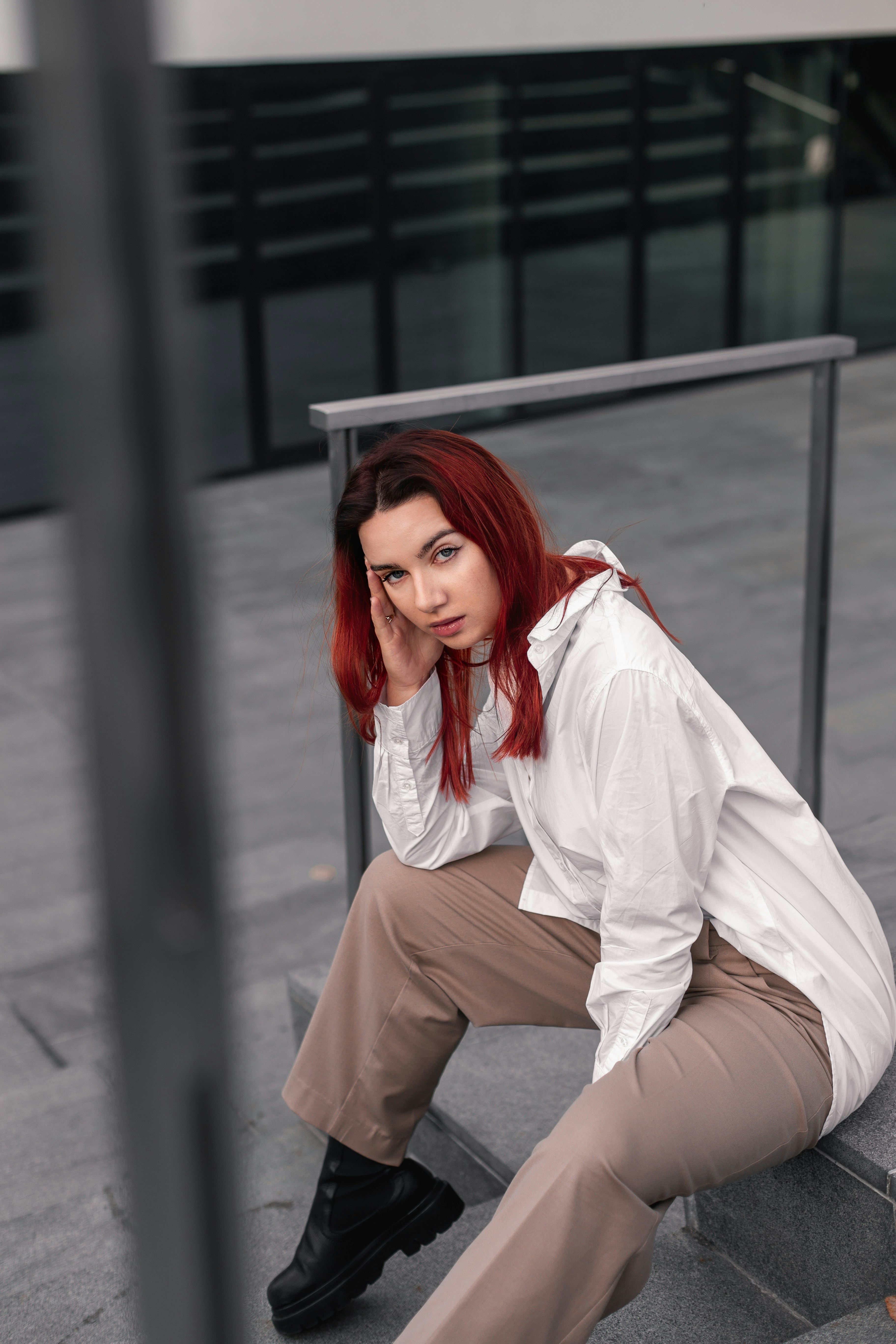 a woman with red hair is sitting on the stairs