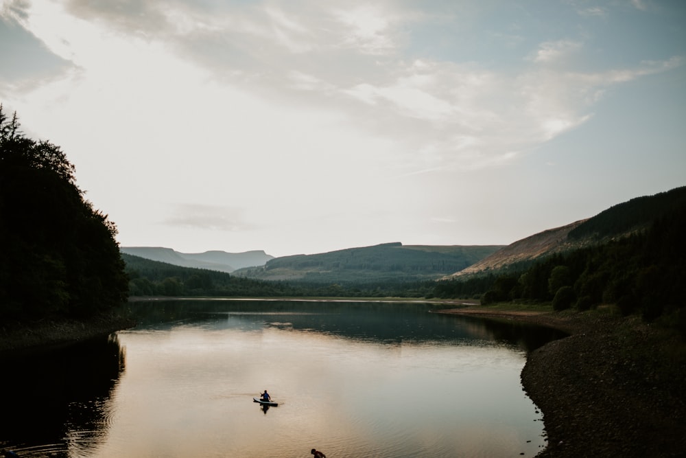 a person in a small boat on a lake