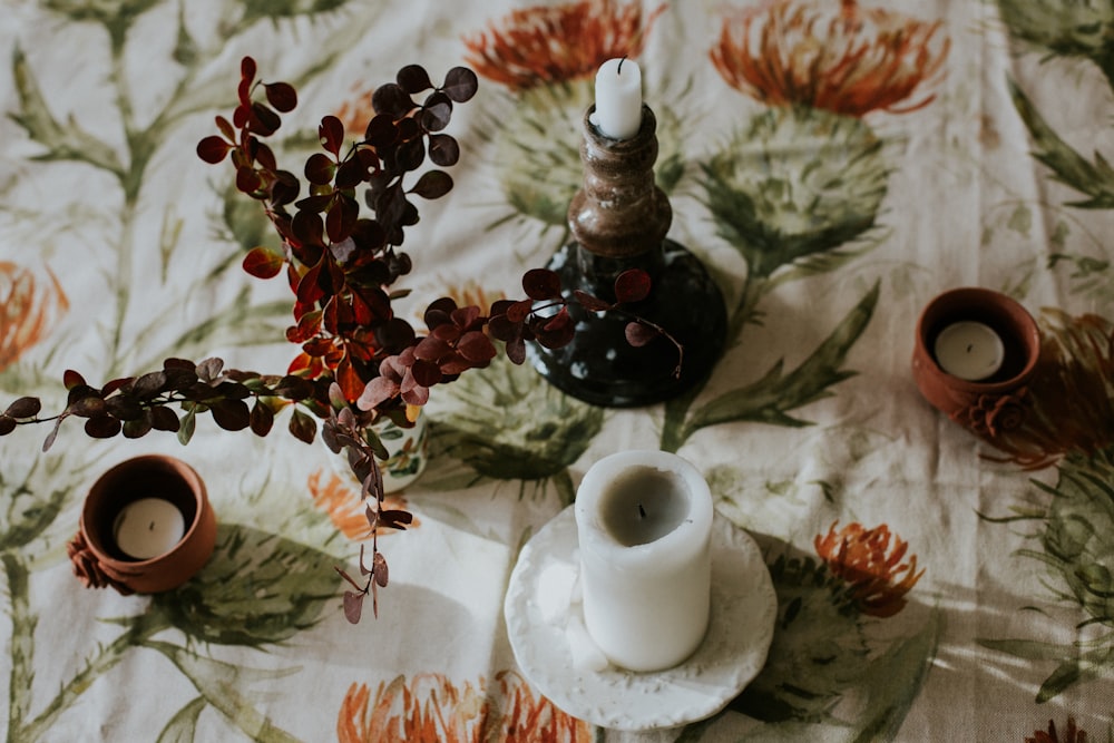 a table topped with candles and a vase filled with flowers