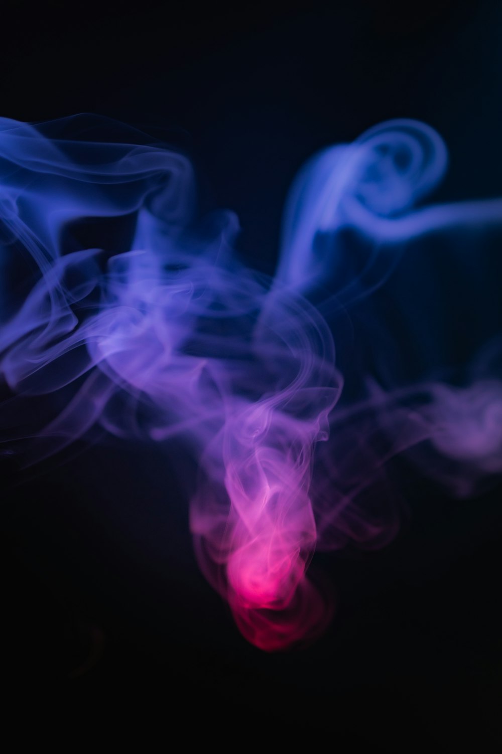 a red and blue smoke is on a black background